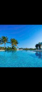 una grande piscina di acqua blu con palme di Adriana Rinaldi Gonçalves ad Angra dos Reis