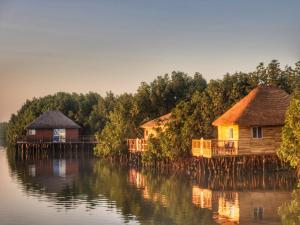 a group of houses on a body of water at Bintang Bolong Lodge in Bintang