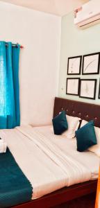 - un lit avec des oreillers bleus et blancs dans l'établissement Baga Beach Paradise, à Baga
