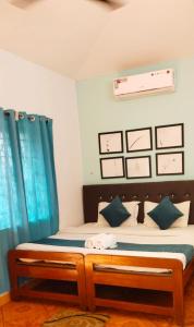 a bedroom with a bed with blue curtains at Baga Beach Paradise in Baga