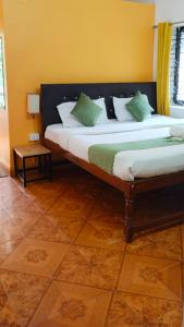 a bedroom with two beds with green and white pillows at Baga Beach Paradise in Baga