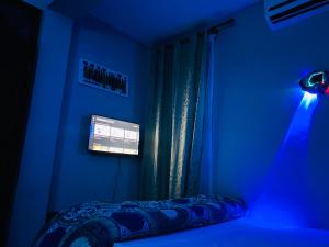 a blue room with a bed and a window at One bedroom serviced apartment in Dar essalaam in Dar es Salaam