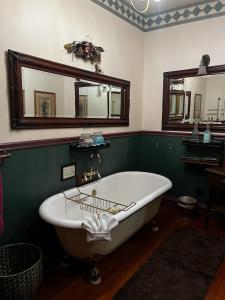a bath tub in a bathroom with a mirror at The National Hotel in Jamestown