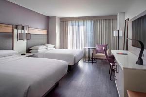 ローリーにあるRaleigh Marriott City Centerのベッド2台と机があるホテルの部屋