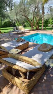 a group of tables and chairs next to a swimming pool at VILLA PASCHMINA PISCINE CHAUFFEE in Ourika
