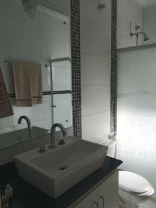 a bathroom with a sink and a toilet at Pousada La Casona in Tibagi