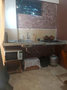 cocina con encimera con fregadero y microondas en Casa Boa Venttura Piscina,guajiru,flecheiras e mundaú en Trairi