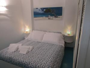 a small bedroom with a bed with two towels on it at Piazzetta Sweet Home in Capri