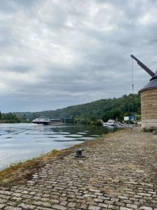 a building next to a river with a boat at Öko Lehmbau direkt am Main in Marktbreit