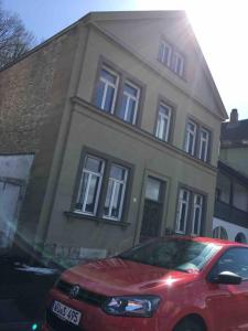 a red car parked in front of a house at Öko Lehmbau direkt am Main in Marktbreit