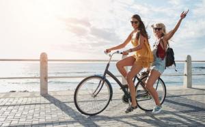 two girls riding a bike on a pier near the water at Grunwaldzka 12 A4 Easy-Rent Apartments - 50m od plaży z dużym tarasem in Pobierowo