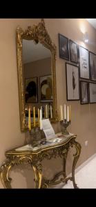 a mirror on a wall with a table with candles at TIZIANA'S HOUSE in Salerno