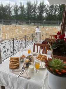 a table with a white table cloth with food on it at Bujtina ALDOR in Berat