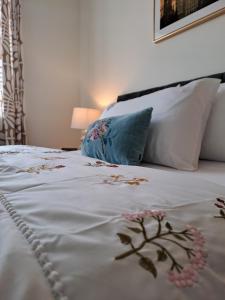 uma cama com lençóis brancos e flores em Cozy bedroom in Lucan, Dublin em Dublin