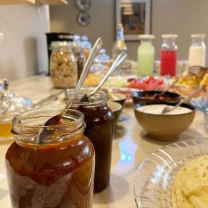 a table topped with jars of honey and plates of food at Vila Dunavski Raj in Golubac