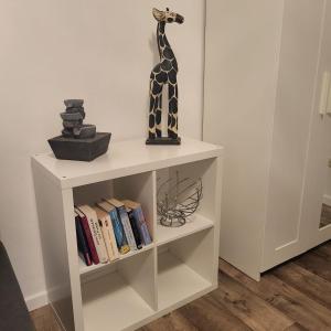 a book shelf with a giraffe statue on top of it at Gemütliche Appartement in Bad Oeynhausen