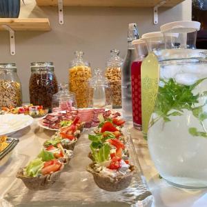 a table topped with baskets of food and a bowl of water at Vila Dunavski Raj in Golubac