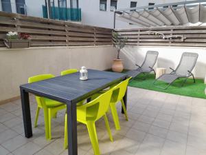 a patio with a table and yellow chairs at Apartamento Lliris Sol in L'Estartit