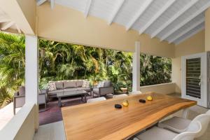 un salon avec une table et des chaises en bois dans l'établissement Attractive villa in resort, à Willemstad
