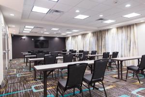 a conference room with tables and chairs and a screen at Residence Inn by Marriott Oklahoma City Northwest in Oklahoma City