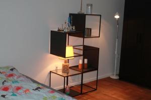 1 dormitorio con estante y lámpara junto a la cama en Anneks med eget toilet og bad - gratis parkering, en Horsens