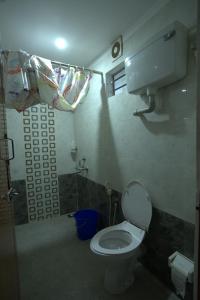 a small bathroom with a toilet and a shower at Garggi Backwater Retreat in Kottayam