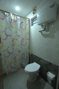 a bathroom with a toilet and a shower curtain at Garggi Backwater Retreat in Kottayam