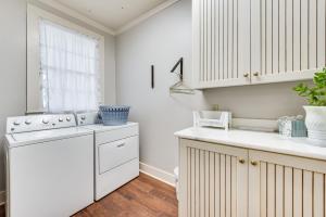 a kitchen with white cabinets and a white dishwasher at Historical 1835 Home in Grand Coteau! in Sunset