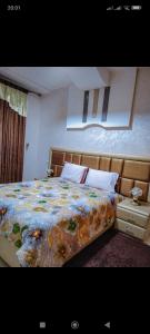 1 dormitorio con 1 cama con manta de flores en FATIMA.MARHABA, en Azrou