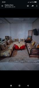 a living room with two beds and a table at FATIMA.MARHABA in Azrou