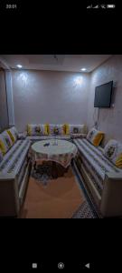 een kamer met twee bedden en een tafel erin bij FATIMA.MARHABA in Azrou