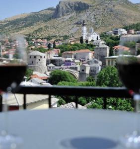 una mesa con copas de vino y vistas a la ciudad en Captain's Luxury Apartments, en Mostar