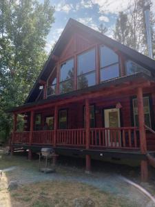 uma grande cabina de madeira com um grande deque em Hearthstone Elegant Lodge em Kamiah