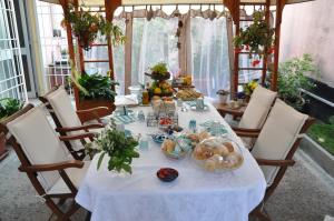 a table with a white table cloth and some food on it at B&B Iulia Augusta in Albenga