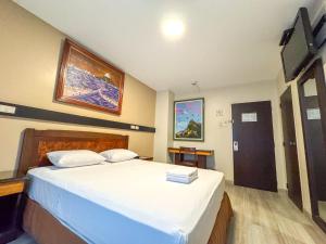 1 dormitorio con 1 cama grande con sábanas blancas en GH Alexander Hotel en Guayaquil