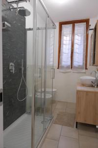 a bathroom with a glass shower and a sink at Ca' Sunin Bellagio - mountains view apartment in Bellagio