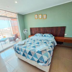 1 dormitorio con 1 cama con edredón azul y blanco en Hotel Costa Sur, en Camaná