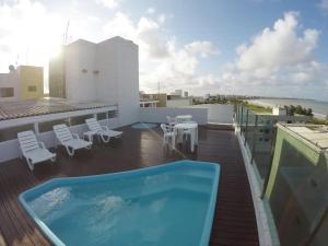 balcón con bañera de hidromasaje, mesas y sillas en Flat Premium - Bessa - Praticamente Beira Mar, en João Pessoa