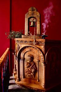 a wooden fireplace with a statue on it in a room at VASILIKON Hotel 1888 the past is present in Kalamata