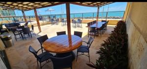a patio with a table and chairs and the ocean at Flat na Praia de Iracema 105 in Fortaleza