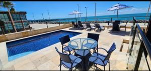a patio with a table and chairs next to the beach at Flat na Praia de Iracema 105 in Fortaleza