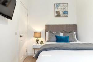 a bedroom with a large bed with blue pillows at NEW Balfour House by Truestays - 5 Bedroom House in Stoke-on-Trent in Etruria
