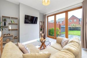 uma sala de estar com um sofá e uma mesa em NEW Balfour House by Truestays - 5 Bedroom House in Stoke-on-Trent em Etruria