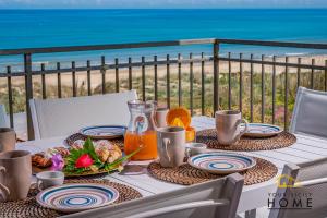 een tafel met eten en uitzicht op het strand bij Casa Vacanze Mare Dorato in Alcamo Marina