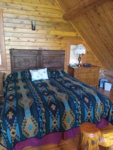 ein Schlafzimmer mit einem Bett in einem Blockhaus in der Unterkunft Hearthstone Elegant Lodge in Kamiah