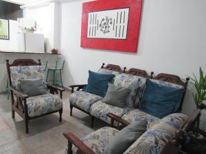 瓜鲁柳斯Hostel Brasil Gru的客厅配有椅子、沙发和图片