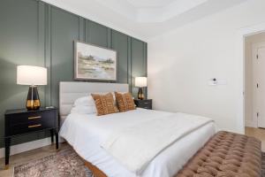 1 dormitorio con 1 cama blanca grande y 2 lámparas en 27 on Park Boutique Hotel & Venue, en Dahlonega
