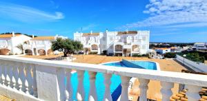 een balkon met uitzicht op een huis en een zwembad bij Apartamento 308 Castell Sol CB in Es Mercadal