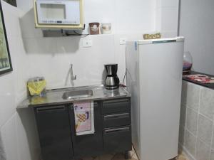 a small kitchen with a sink and a refrigerator at Hostel Brasil Gru in Guarulhos