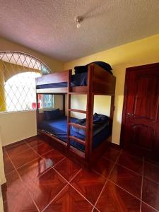 a room with two bunk beds in a room at Lujosa casa cerca del aeropuerto en TUMBACO CENTRO in Quito